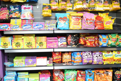 Interior view of Candy Cream Bathgate showing shelves stocked with packaged 
international sweets, crisps, candy, and American snacks like Nerds and Cheetos